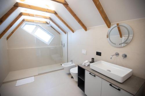 un bagno con lavandino, WC e specchio di Ginger Home Studio a Tirana