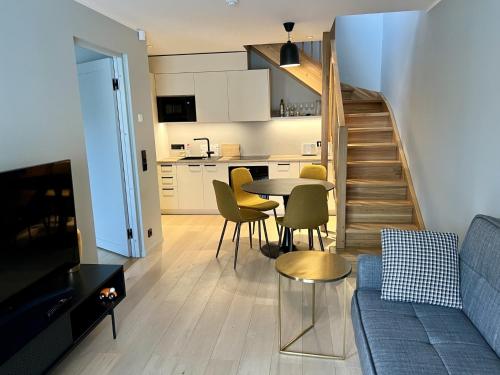 a living room with a couch and a table with chairs at Saue Apartment in Haapsalu