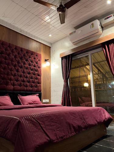 a bedroom with a large bed with a red headboard at Imagine Love in Lonavala