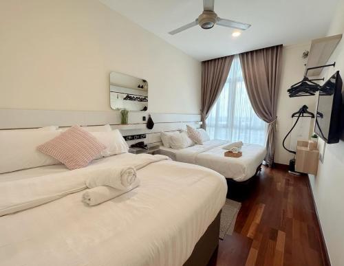 Cette chambre comprend 2 lits et une télévision à écran plat. dans l'établissement Paragon Suites Holiday Short gateway Jacuzzi CIQ, à Johor Bahru