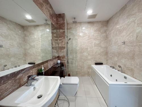 La salle de bains est pourvue d'un lavabo, d'une baignoire et de toilettes. dans l'établissement Paragon Suites Holiday Short gateway Jacuzzi CIQ, à Johor Bahru