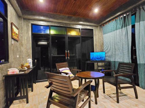 a room with a table and chairs and a television at Baan Koh Kwang Pool Villa Krabi in Krabi town