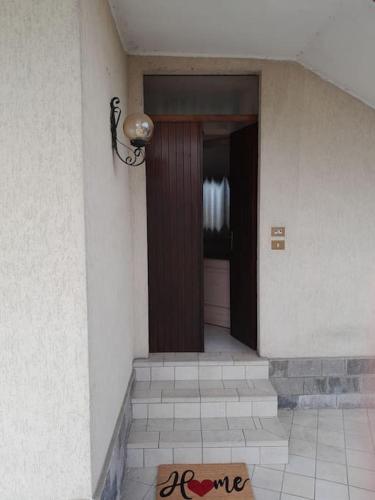 um corredor com uma porta castanha e piso em azulejo em Appartamento da Sara rb em Paruzzaro