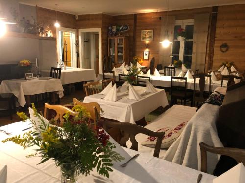 ein Restaurant mit Tischen und Stühlen mit weißem Tischtuch in der Unterkunft Vehkaniemen Lomatila in Pohjaslahti