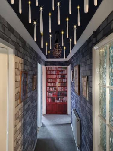 a hallway with a red door with bookshelves at Apartment 9 3/4 in Watford