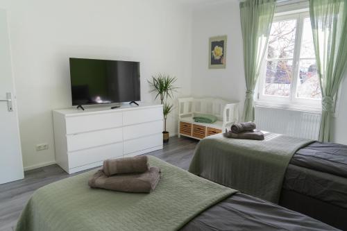 1 Schlafzimmer mit 2 Betten und einem Flachbild-TV in der Unterkunft WILSON's Home Baden City Center operated by revLIVING in Baden