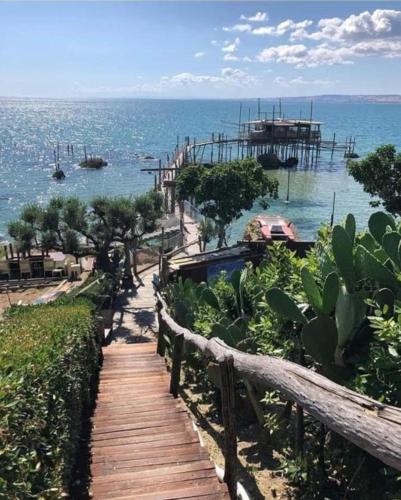 a wooden pathway leading to the ocean with a pier at OLTRE CONFINE fronte mare in Marina di Montenero