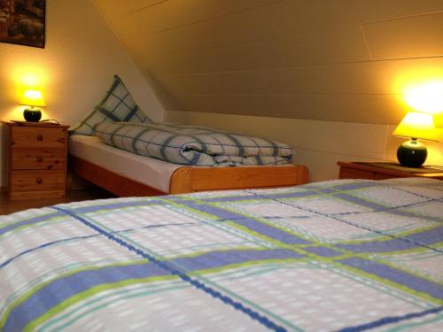 two beds in a bedroom with two lamps on tables at Am-Deichtor in Dornumersiel