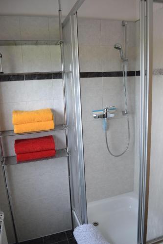 a bathroom with a shower with towels and a tub at Am-Deichtor in Dornumersiel