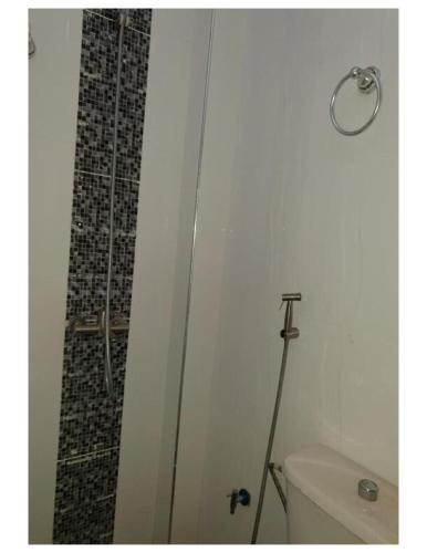 a bathroom with a toilet and a glass shower door at Belle Appartement avec Jaccuzzi à Diamniadio in Dakar