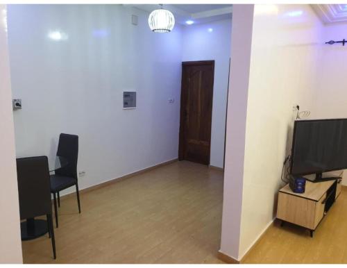 a room with two chairs and a television and a door at Belle Appartement avec Jaccuzzi à Diamniadio in Dakar
