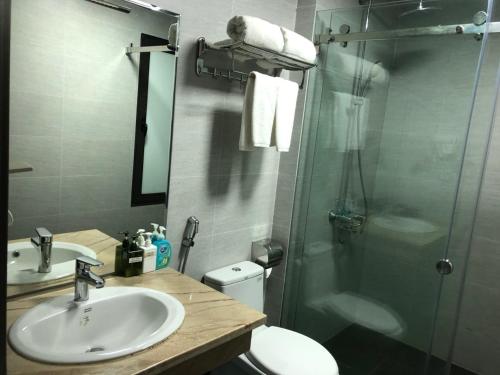 een badkamer met een douche, een wastafel en een toilet bij Hotel Nam Sơn Tân Dương in Chơ Mơi