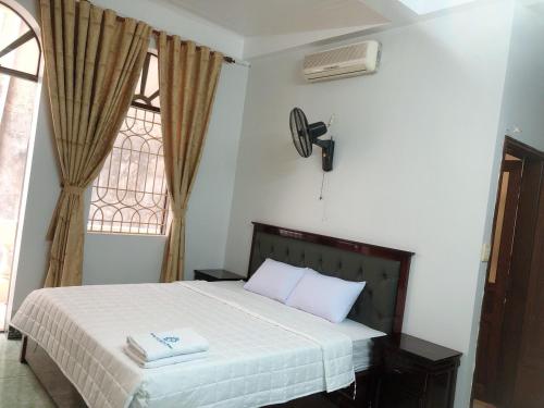 een slaapkamer met een bed met twee handdoeken erop bij Hotel Nam Sơn Tân Dương in Chơ Mơi