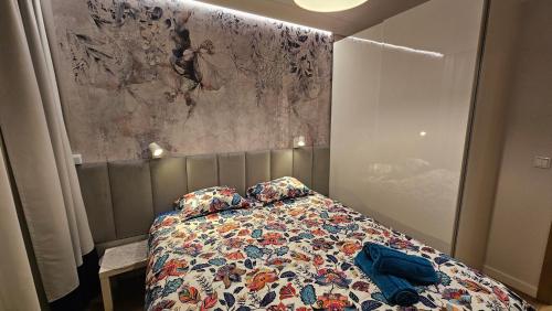 a bedroom with a bed with a comforter and pillows at Apartament Elegance, Metro, free parking in Warsaw