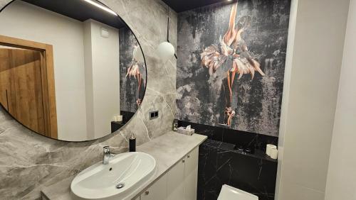 a bathroom with a sink and a mirror at Apartament Elegance, Metro, free parking in Warsaw