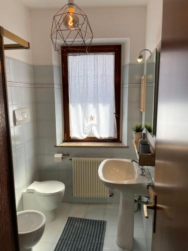 a bathroom with a sink and a toilet and a window at Villa Anna in Grado