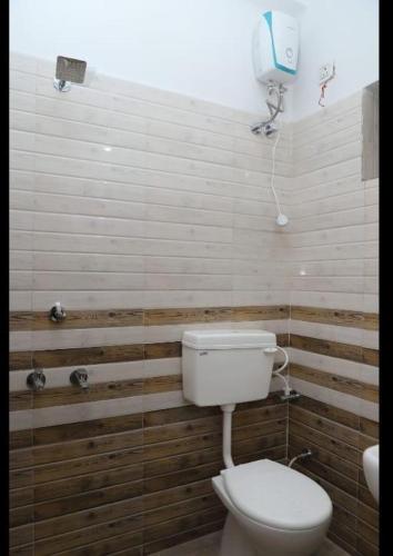 a bathroom with a toilet and a phone on the wall at HOTEL PARADISE INN in Shinaya