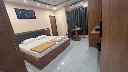 HOTEL PARADISE INN في Shinaya: غرفة نوم فيها سرير ومكتب