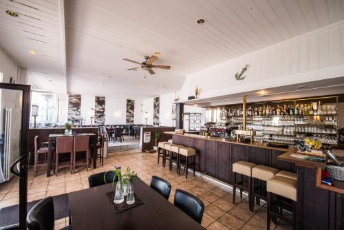 ein Restaurant mit Tischen und Stühlen und eine Bar in der Unterkunft Hotel am Yachthafen in Konstanz