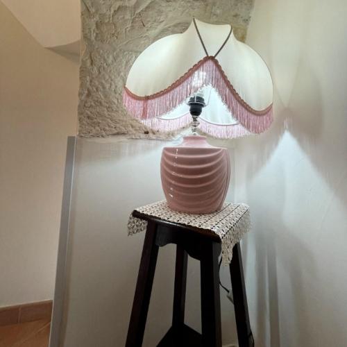 a pink lamp sitting on a stool next to a wall at RosaLilli in Locorotondo