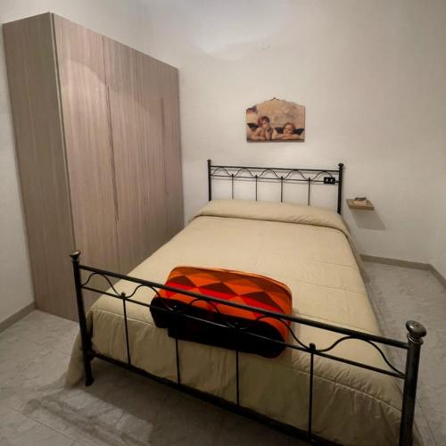 a bed with an orange blanket on it in a room at RosaLilli in Locorotondo