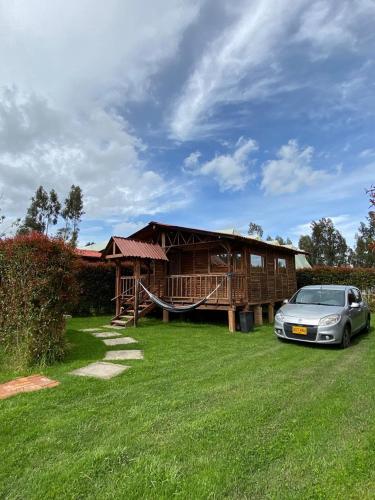 a house with a car parked in front of it at CABAÑAS VILLA INES DE SUESCA in Suesca