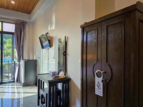 a room with a wooden door and a table at Baan Koh Kwang Pool Villa Krabi in Krabi town