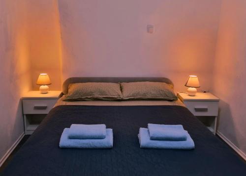 1 dormitorio con 1 cama con 2 toallas en Apartment Port of happiness, en Krnica