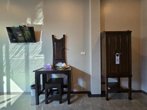 a table with a chair and a tv on a wall at Baan Koh Kwang Pool Villa Krabi in Krabi town