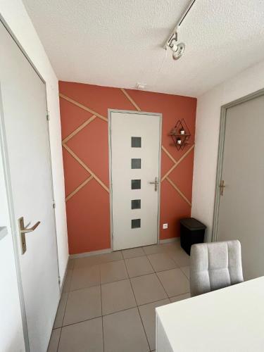 - un couloir avec une porte et une chaise dans la chambre dans l'établissement Appartement devant la mer + parking, au Grau-du-Roi