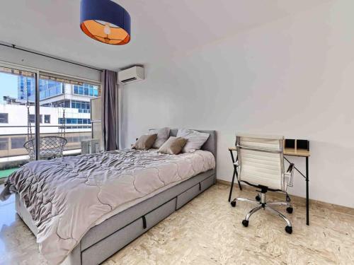 une chambre avec un lit, un bureau et une chaise dans l'établissement 1 min to beach with parking 3 bedroom flat (2 AC), à Nice