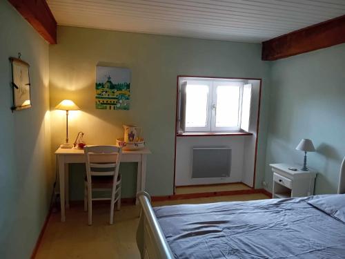 une chambre avec un lit, un bureau et une fenêtre dans l'établissement Gîte Sèvremoine Bois Buteau, à Montfaucon