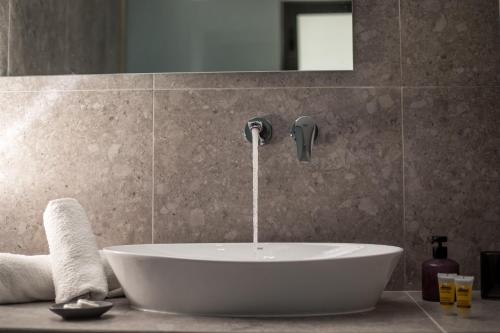 a bath tub with a faucet in a bathroom at Dias Studios & Suites in Faliraki