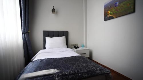 małą sypialnię z łóżkiem z kocem w obiekcie VE HOTELS KAPADOKYA w mieście Nevşehir