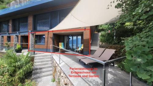 a house with a porch and a chair on a balcony at Villa Bootsmann mit spektakulärer Seesicht nahe Badestrand in Vitznau