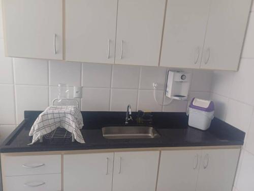 a kitchen counter with a sink and a towel at Casa do Vô Luiz in Vila Velha