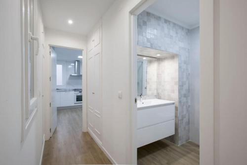 ein weißes Badezimmer mit einem Waschbecken und einem Spiegel in der Unterkunft Alhóndiga Flat by Next Stop Bilbao in Bilbao