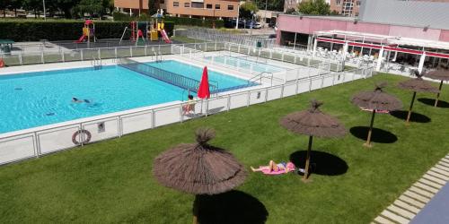 una vista aérea de una piscina con sombrillas en Apartamentos GO Covaresa -Parking Gratuito, en Valladolid