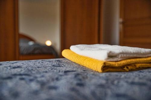 une pile de serviettes posée sur un lit dans l'établissement Maison familiale proche du lac, à Biscarrosse