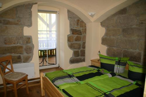 a bedroom with a green bed and a window at Ferienhof An der Weide in Kurort Gohrisch