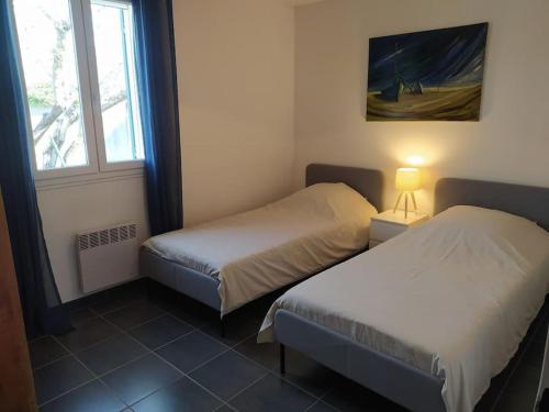 une chambre avec deux lits et une fenêtre dans l'établissement Maison en Provence, à Entraigues-sur-la-Sorgue