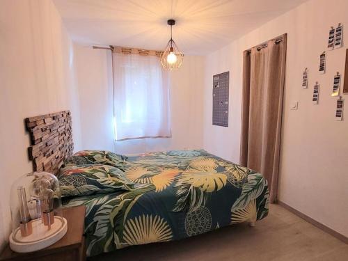 - une chambre avec un lit à motifs tropicaux dans l'établissement Villa duplex avec piscine et Spa, à Néoules