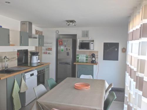 une cuisine avec une table et une cuisine avec une table et des chaises dans l'établissement Villa duplex avec piscine et Spa, à Néoules