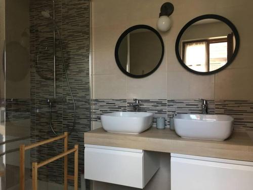 une salle de bain avec deux lavabos et un miroir dans l'établissement Gîte familial, 6 personnes (15 min Zoo de Beauval), à Lye