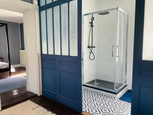 ein Bad mit einer Dusche und einer blauen Tür in der Unterkunft Brigitte et Moi in Chancelade