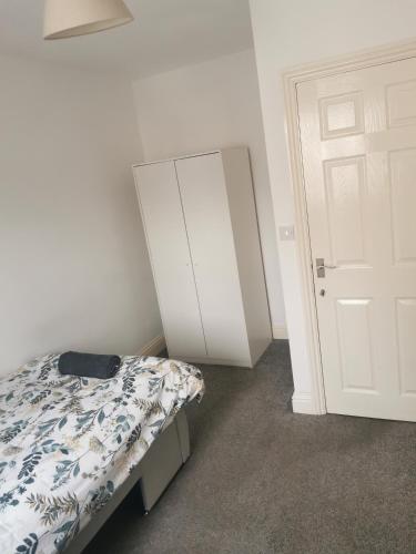 a bedroom with a bed and a white cabinet at FFSGL3 in Barking
