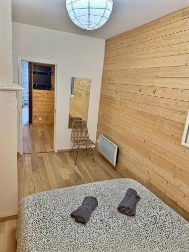 - une chambre avec un lit et un mur en bois dans l'établissement WonderHost, bois et pierre en cœur de ville, à Pau