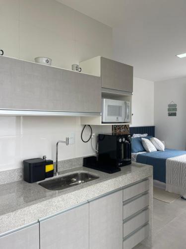 a kitchen with a sink and a bed in a room at Loft Pelicano Prainhas- Pontal do Atalaia- Para Casal - com Hidro in Arraial do Cabo