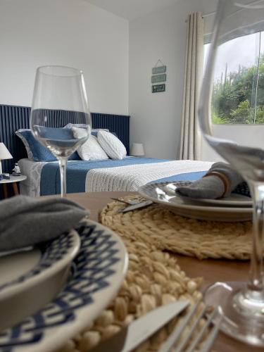 a table with plates and wine glasses on a table at Loft Pelicano Prainhas- Pontal do Atalaia- Para Casal - com Hidro in Arraial do Cabo