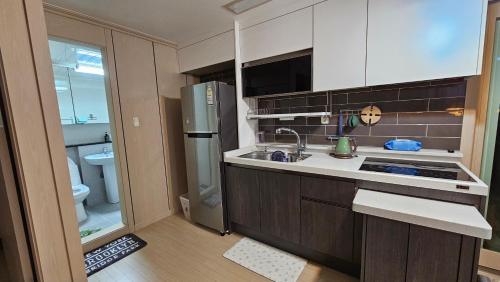 uma pequena cozinha com um lavatório e um frigorífico em My comfortable second house em Seul